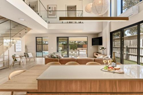 a dining room and living room with a dining table at Bonnyvale Dune Retreat I Ocean Grove in Ocean Grove