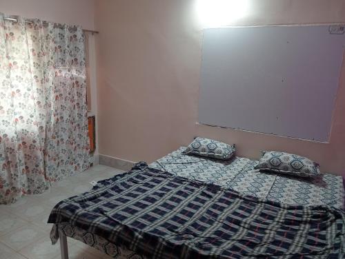 een bed met twee kussens erop in een kamer bij Surya Vinayak Homestay in Ghātsīla