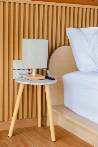 a bedside table with a lamp next to a bed at Yugen House - Yuma in Nong Prue