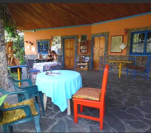 a room with a table and chairs and people in the background at La Lune Topaz in Boquete
