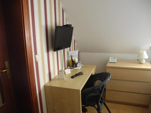 a hotel room with a desk with a tv on it at Paciello Restaurant Hotel in Velbert