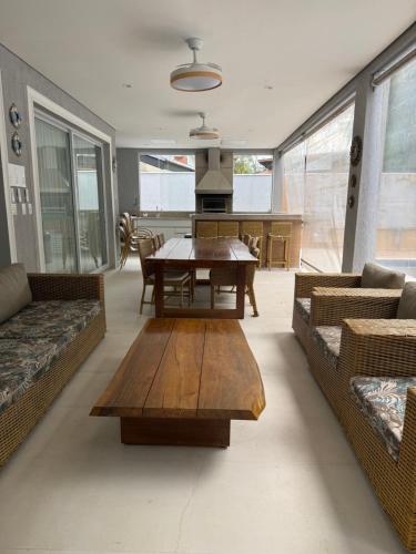 a living room with a table and a dining room at Casa Riviera Prime in Riviera de São Lourenço