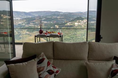 a living room with a couch and a table with a view at Cherry Douro Hill in Resende