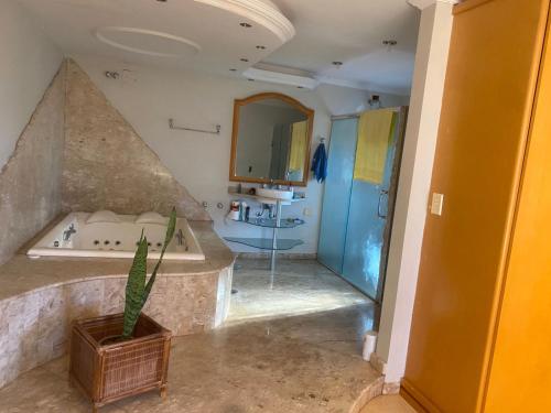 a bathroom with a tub and a sink at Med House in Guaíra