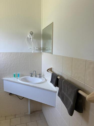a white bathroom with a sink and a mirror at Wee Waa Motel in Wee Waa