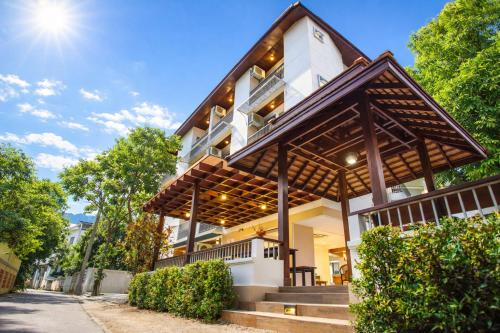 a white building with a gambrel roof at Rendezvous Classic House in Chiang Mai