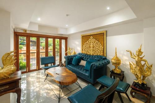 a living room with a blue couch and a table at Rendezvous Classic House in Chiang Mai