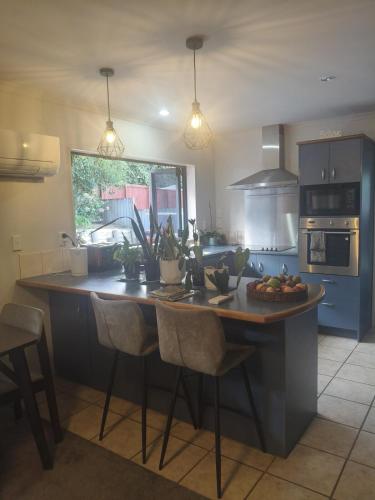 a kitchen with a table with a bowl of fruit on it at House On The Hill in Hamilton