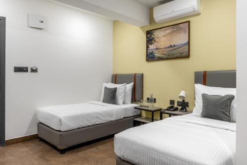 une chambre d'hôtel avec deux lits et une table dans l'établissement Wandr Hotel Richmond Road, à Bangalore