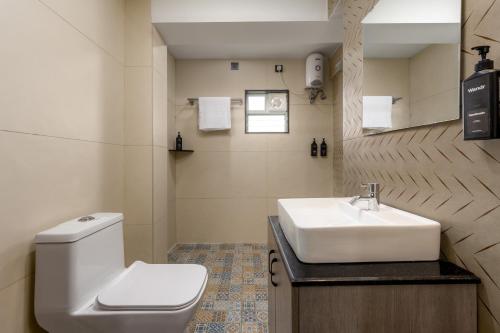 un bagno con un lavandino bianco e un water di Wandr Hotel Richmond Road a Bangalore