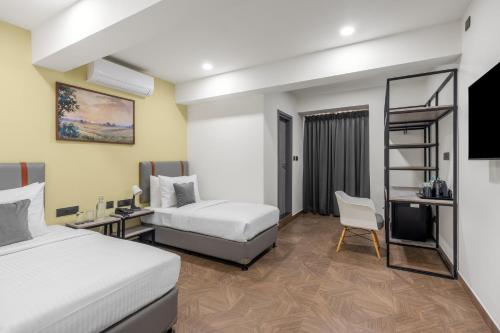 a hotel room with two beds and a television at Wandr Hotel Richmond Road in Bangalore