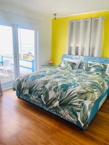 a bedroom with a bed with a colorful comforter at Breaker Bay Paradise in Wellington