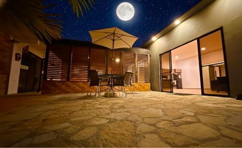 a table with chairs and an umbrella in a house at LUZ DE LUNA mesa de los santos house in Los Santos