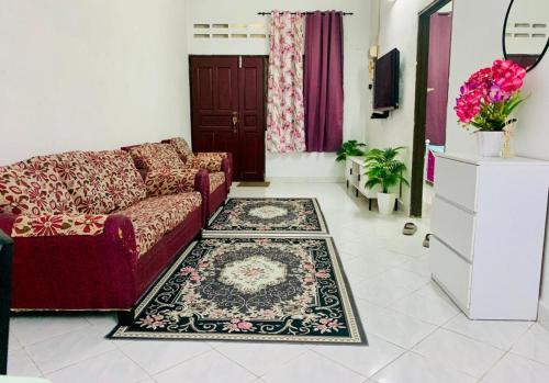 a living room with a couch and a rug at Homestay Hayyan in Kampong Terbak