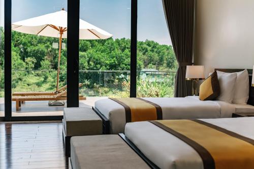 a hotel room with three beds and a large window at Lamori Resort & Spa in Thanh Hóa