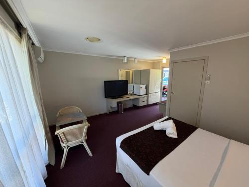 a hotel room with a bed and a television at Ringwood Lake Inn in Ringwood