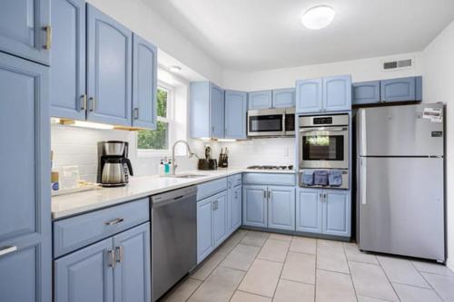 een blauwe keuken met witte apparatuur en blauwe kasten bij Forest Glen Silver Spring Gem - Parking in Silver Spring