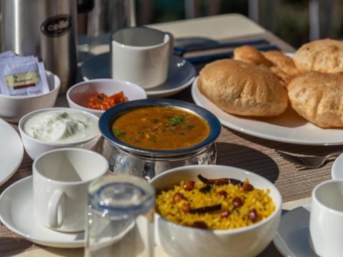 un tavolo ricoperto di ciotole di cibo e pane di Moustache Select Nainital a Nainital