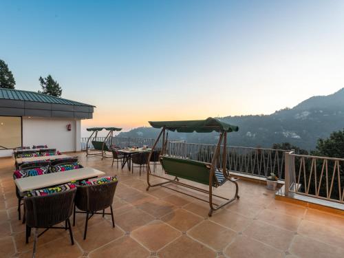 un patio con tavoli e sedie su un balcone di Moustache Select Nainital a Nainital