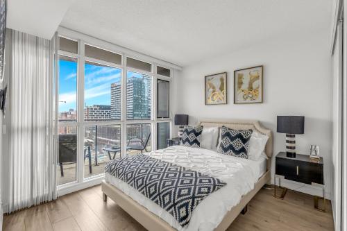 a bedroom with a bed and a large window at Toronto Harbourview Suites with free parking in Toronto