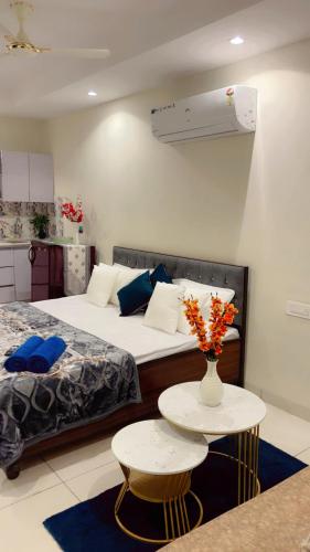 ein Schlafzimmer mit einem Bett und einem Tisch mit einer Blumenvase in der Unterkunft Cherry blossom in Zirakpur
