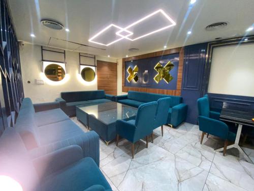 una stanza con sedie blu, tavolo e pianoforte di Hotel N Regency ad Amritsar