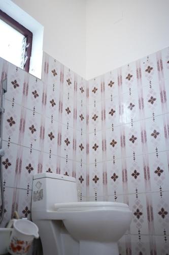 een badkamer met een wit toilet en een wastafel bij Thekkady Arasi Hotel in Thekkady