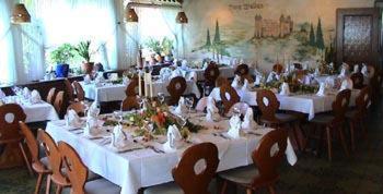 um grupo de pessoas sentadas em mesas em um restaurante em Hotel Burg Waldau em Grasellenbach