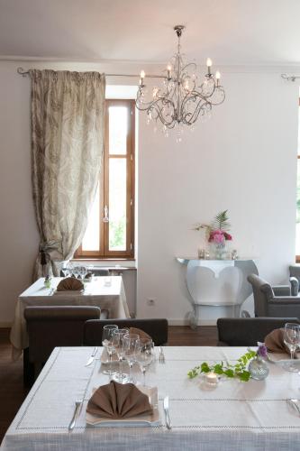 a dining room with two tables and a chandelier at Château - Hôtel Le Sallay in Magny-Cours