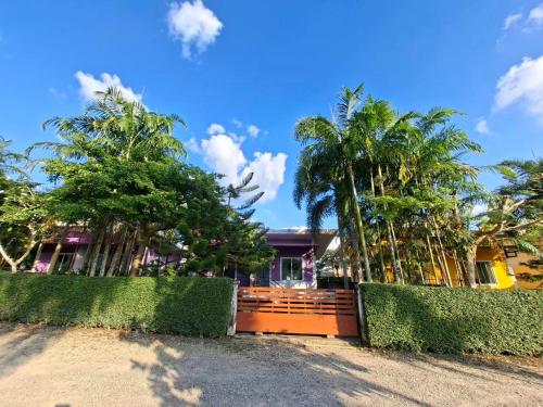 a house with palm trees and a fence at Little Purple House- AoNang in Ao Nang 