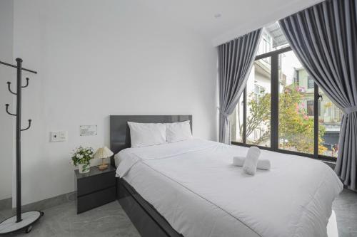 a bedroom with a large bed and a large window at Villa's Võ Thị Sáu Huế in Hue