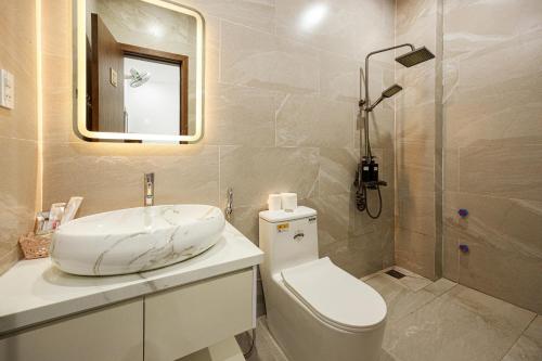 a bathroom with a sink and a toilet and a mirror at Villa's Võ Thị Sáu Huế in Hue