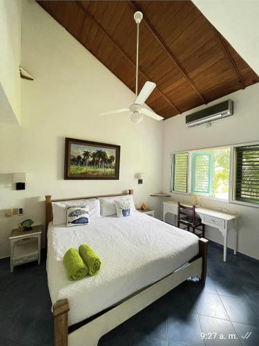 a bedroom with a bed with two green pillows on it at La Dolce Vita 12 Beachfront Hotels, Las Terrenas, Samana in Las Terrenas