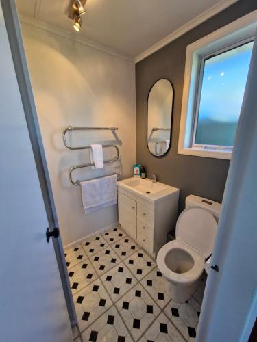 een badkamer met toilet, wastafel en raam bij Country Harbourside Escape in Whakapirau