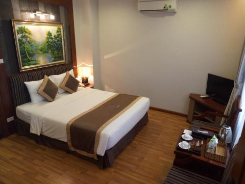 a hotel room with a bed and a television at Gallant Hotel in Hanoi