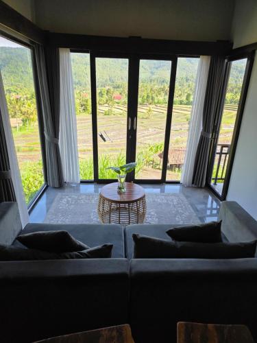 ein Wohnzimmer mit Sofa und Tisch in der Unterkunft MAYURA BALI VILLA in Munduk