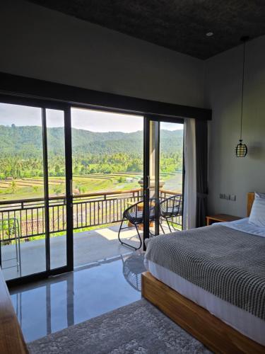 a bedroom with a bed and a balcony with a view at MAYURA BALI VILLA in Munduk