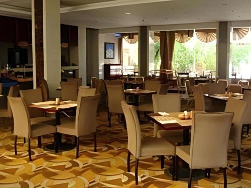 a dining room with tables and chairs in a restaurant at Lijiang Conifer Lishui Yangguang Hotel in Lijiang