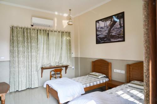 Postel nebo postele na pokoji v ubytování Iskcon Govardhan Retreat Center