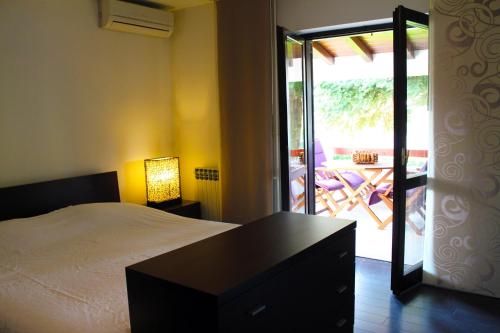 Schlafzimmer mit einem Bett und einer Tür zu einer Terrasse in der Unterkunft Apartment Pinia in Poreč