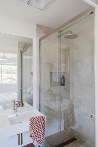 a bathroom with a sink and a shower at Ocean Haze - Putting Green, Firepit, Beach location in Mollymook
