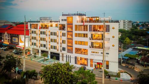 a tall white building in a city at Louis Residence Hotel in Nakhon Ratchasima
