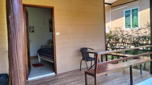 eine Veranda eines Hauses mit einem Tisch und einem Stuhl in der Unterkunft Little Shark bungalow in Ban Bang Bao