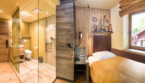 a bathroom with a bed and a glass shower at Boutique Hotel im Auracher Löchl in Kufstein