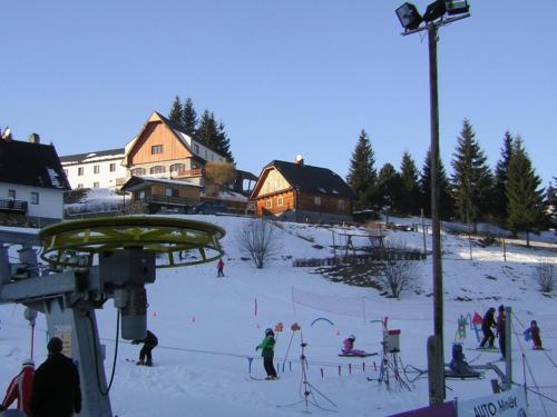 a group of people on a ski lift in the snow at Chata U Vlastíka in Malá Morávka