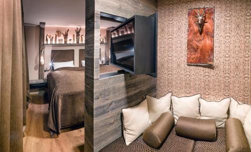 two pictures of a bedroom with a bed and a couch at Boutique Hotel im Auracher Löchl in Kufstein