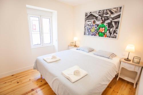 リスボンにあるGraça Traditional 2 bedroom apartmentのベッドルーム1室(白いベッド1台、タオル2枚付)