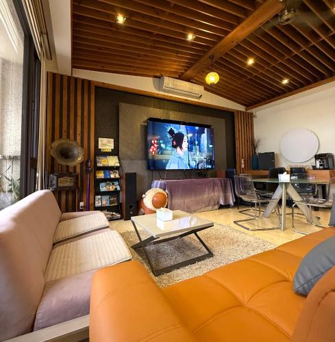 ein Wohnzimmer mit Sofa und Flachbildfernseher in der Unterkunft Love's World B&B in Jian