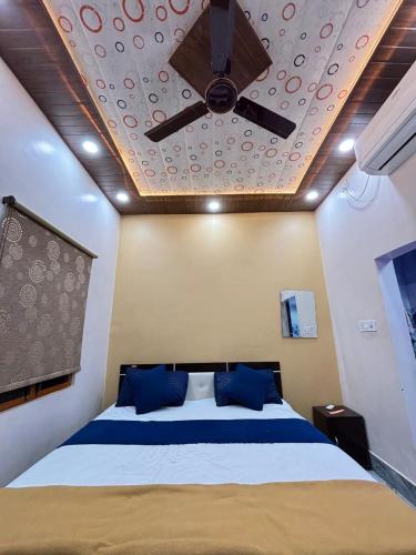 a bedroom with a bed with a ceiling fan at Awadh kunj palace in Ayodhya