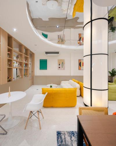 a living room with a yellow couch and a table at Bembis Hotel Charoenakorn 10 in Chinatown
